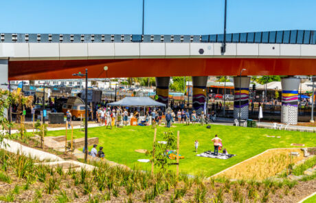 New public space at the Ovingham Level Crossing Removal Project in Adelaide, South Australia, includes gardens, ball courts and largescale mural artworks. Here children and families are pictured in the new gardens and nature play area.