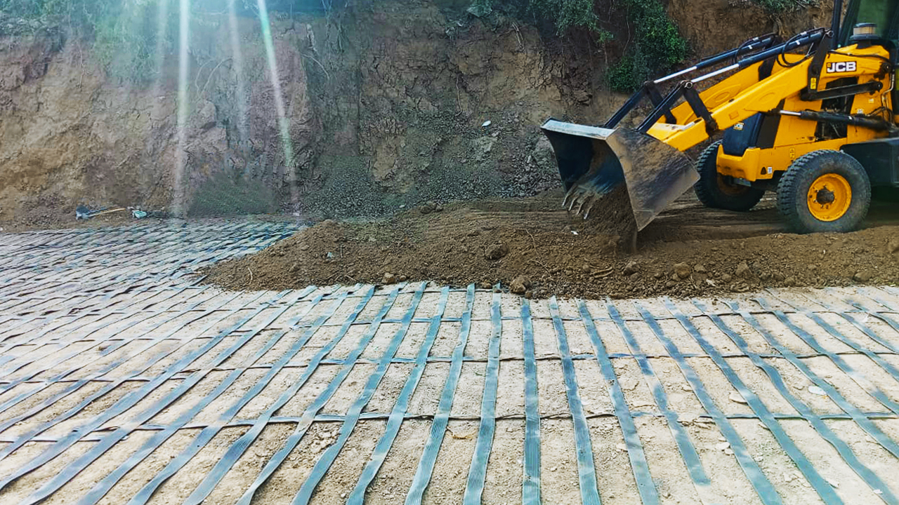 High-strength reinforcement geosynthetic, ArmaLynk geogrid being installed by machinery