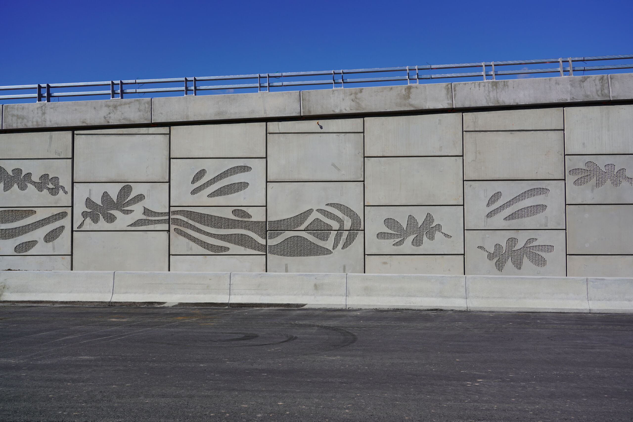 A reinforced earth wall (MSE wall) at the Sydney Gateway project, New South Wales, which has pre cast concrete facing panels with decorative elements engraved.