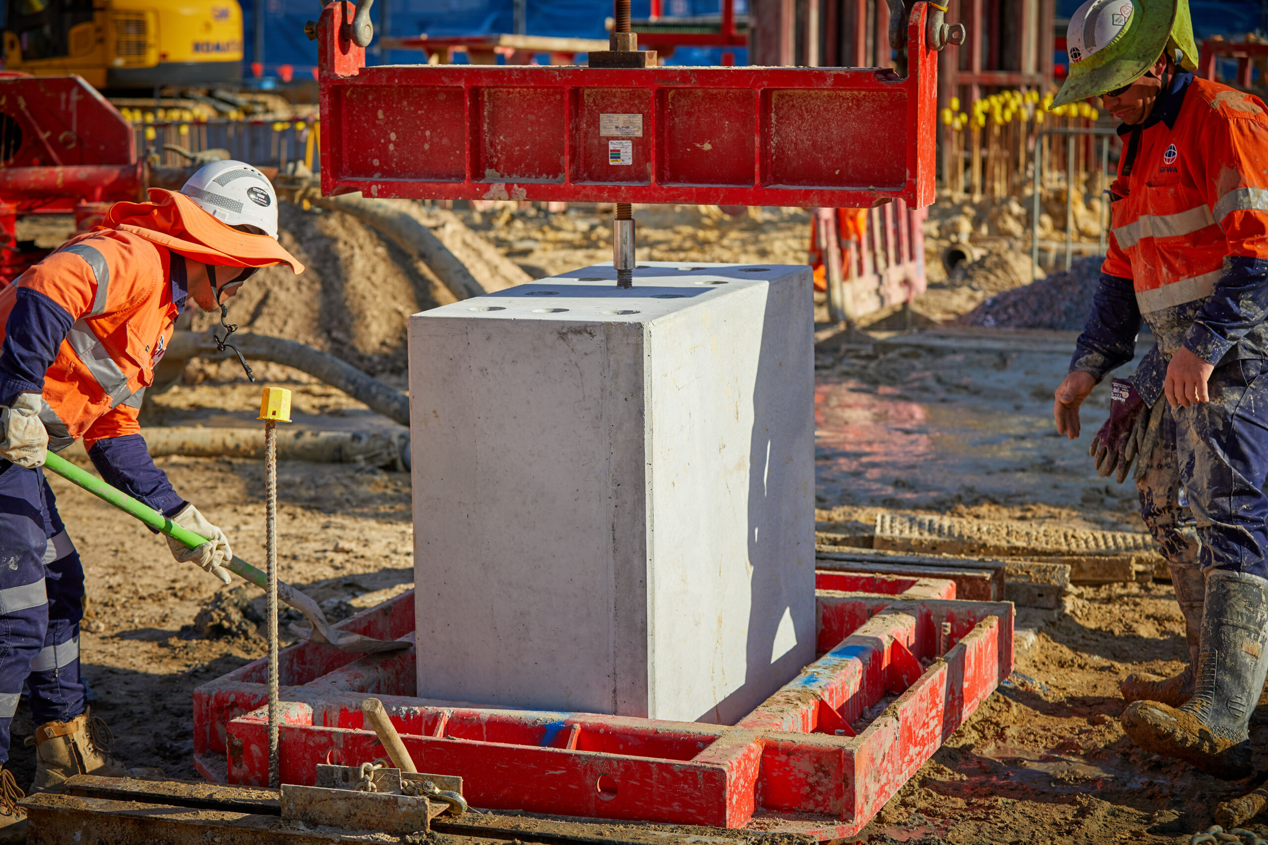 Engineers inspecting a completed reinforced earth wall (MSE wall) in Sydney, New South Wales, which has pre cast concrete facing panels with decorative elements engraved.